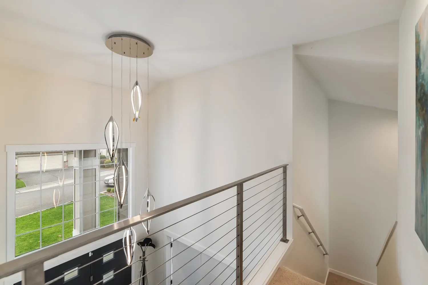 A stair landing painted Westhighland White, with a cable rail and a cluster of glass pendants