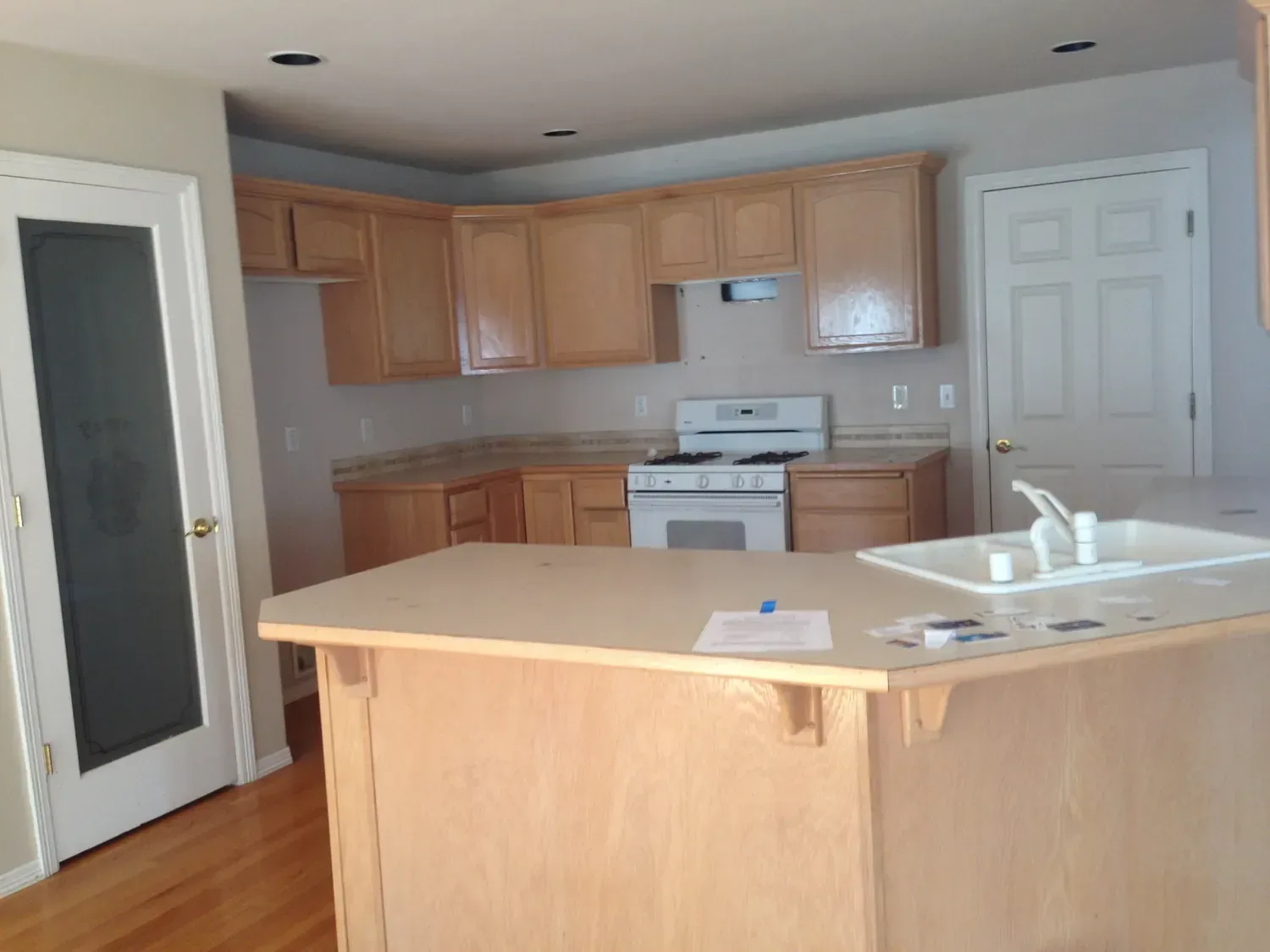 The kitchen before: honey-oak cabinets, laminate counters and a white range