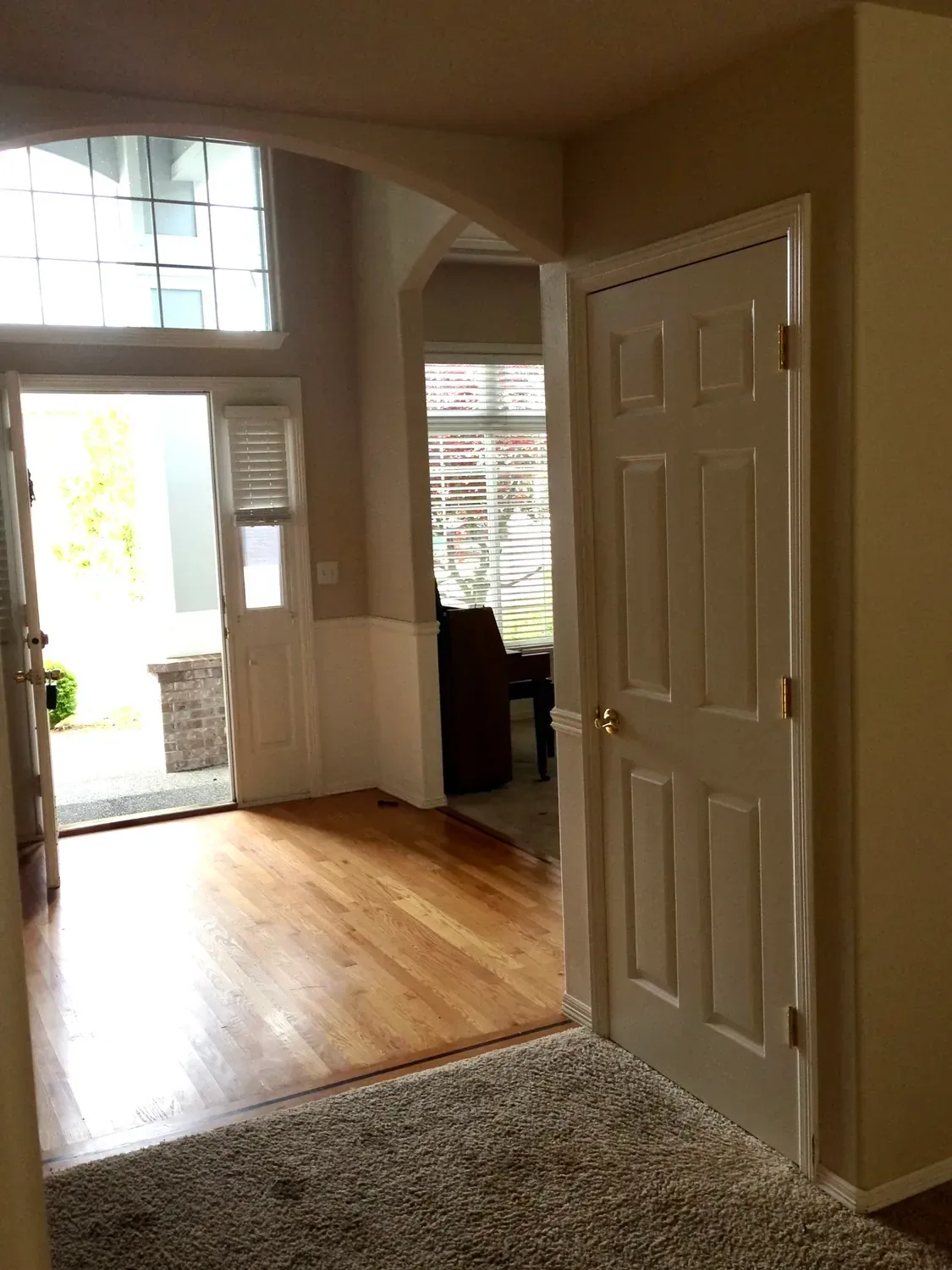 The entry before the remodel: builder-grade six-panel doors, chair rail and beige walls