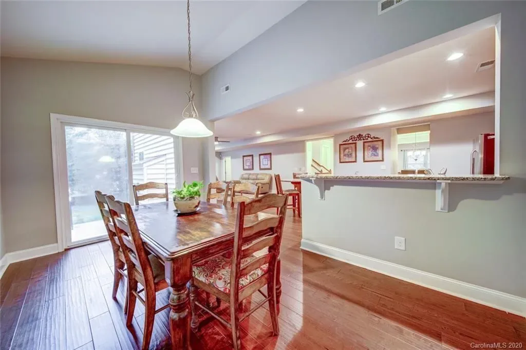 The dining room before: a cherry table and ladder-back chairs under a small white pendant