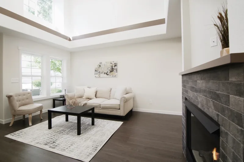 From beside the dark tiled fireplace, the living room again with gas flames lit in the corner