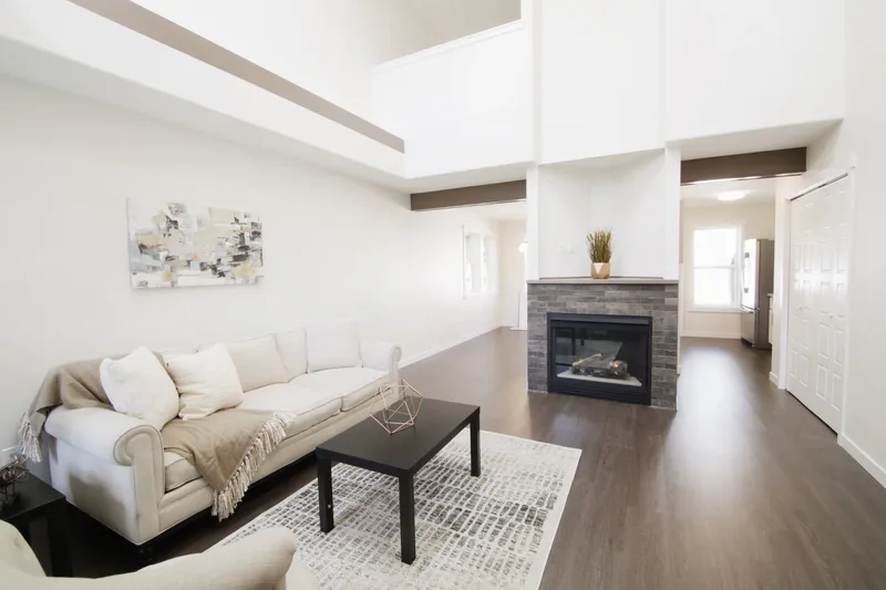 Across the sofa to the tiled fireplace and the hall beyond, double-height ceiling overhead