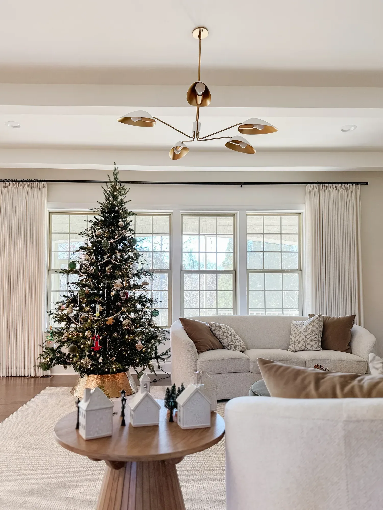Flocked Christmas tree lit in a bright Charlotte living room
