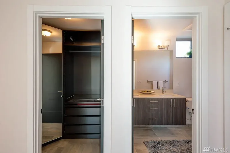 Two open doorways side by side, a fitted walk-in closet on the left and a bathroom vanity on the right