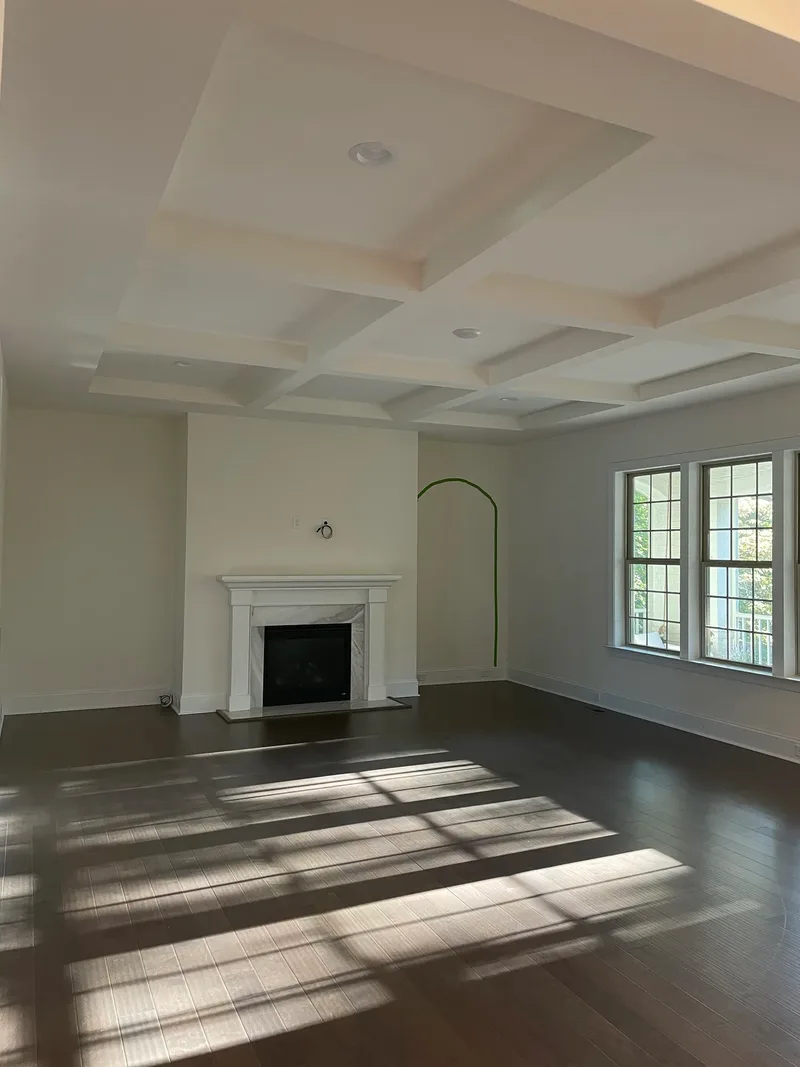 The coffered ceiling from closer in, the taped arch outline still on the wall beside the plain fireplace