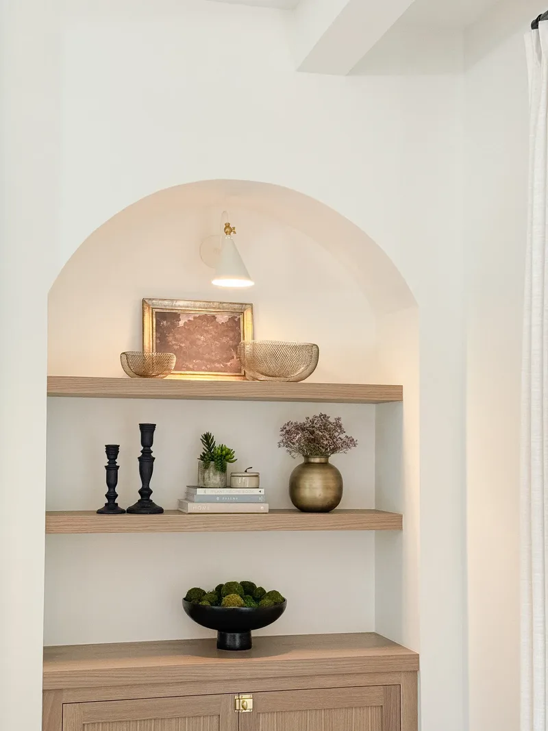 The alcove seen from one side, ceiling beam and curtain edge in frame beside the lit arch