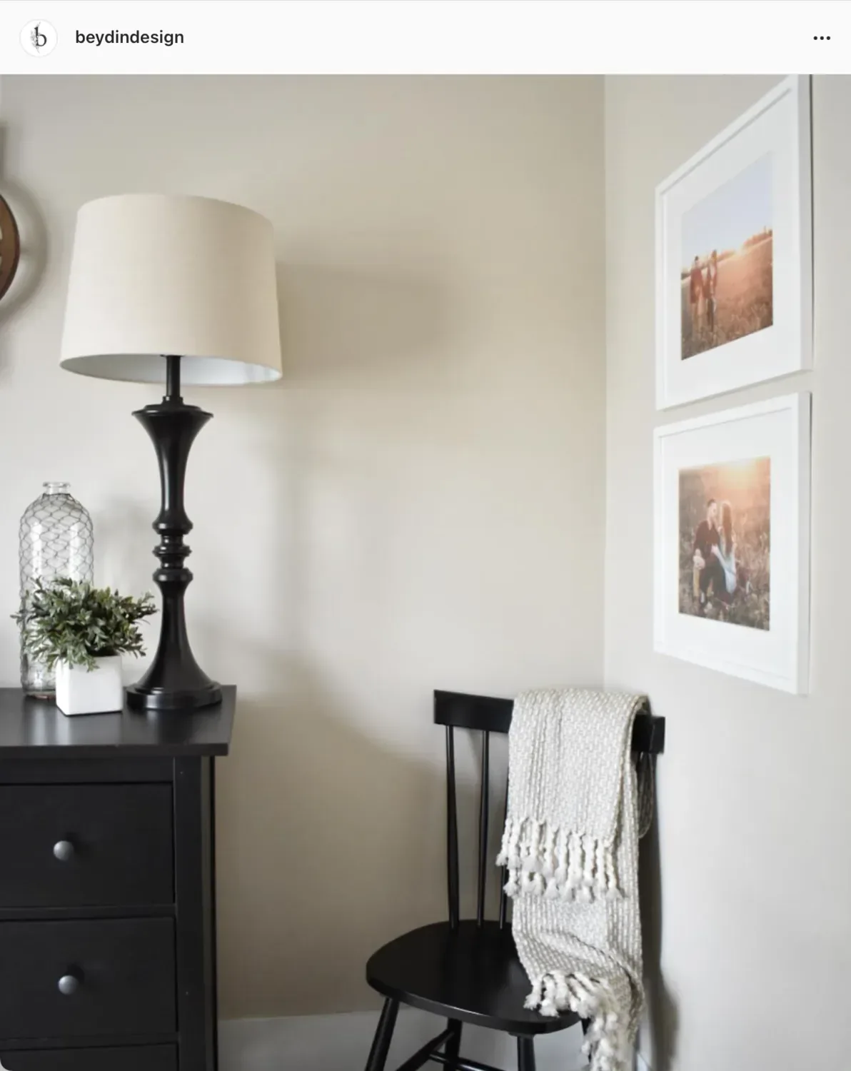 Accessible Beige walls in a corner with a black lamp, framed photographs and a throw over a chair