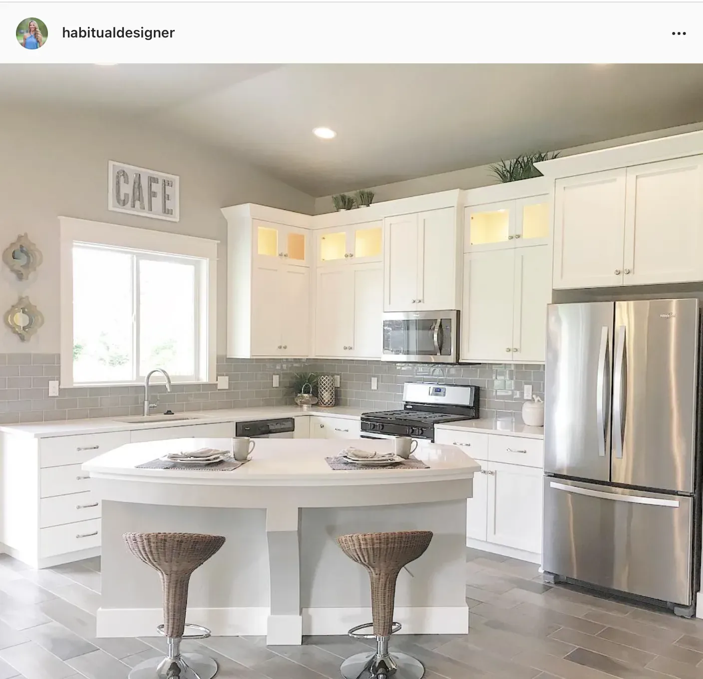 A white kitchen with Westhighland White cabinets, grey subway tile and rattan bar stools