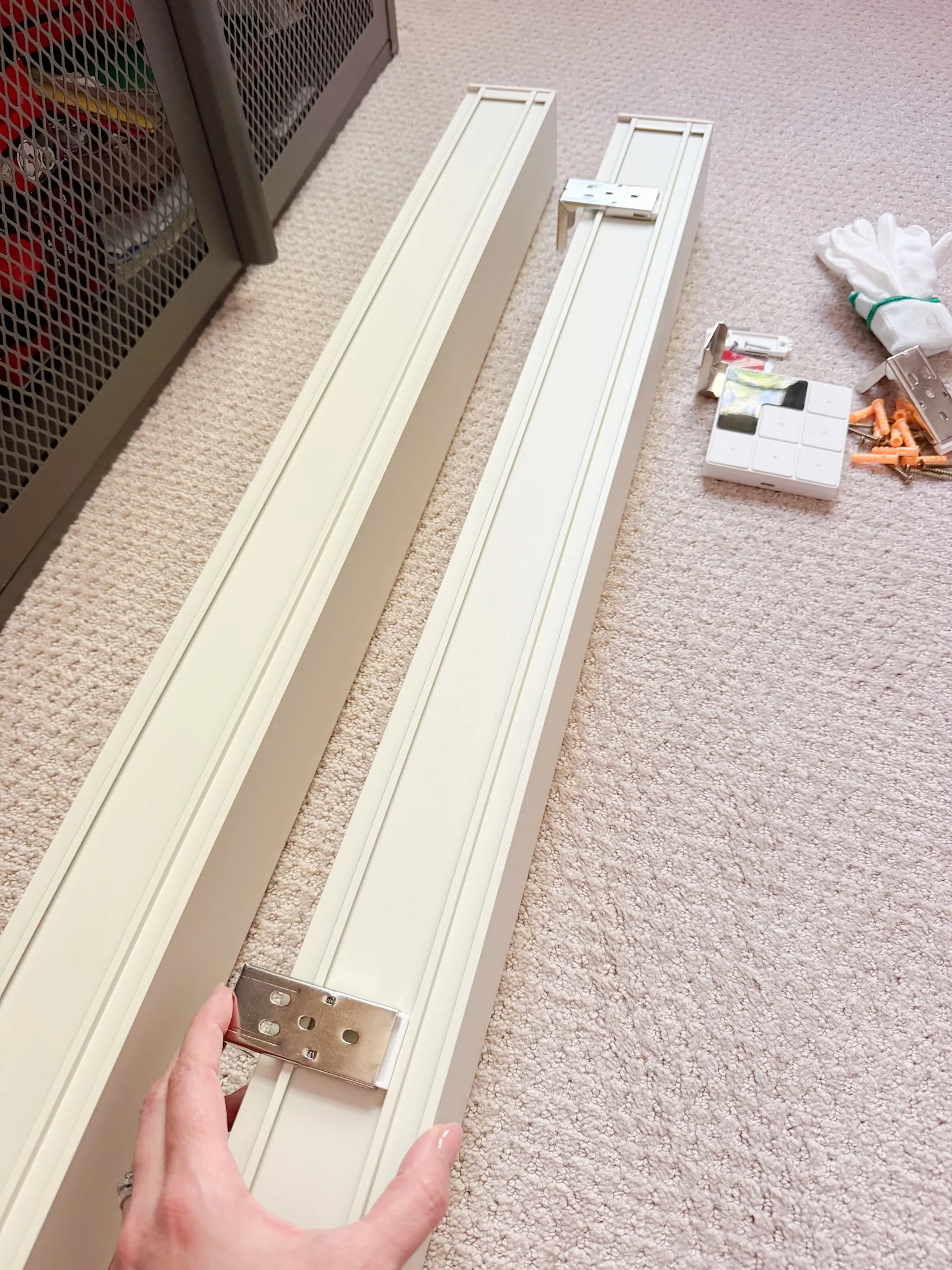 Mounting brackets positioned on the backs of two cream roller shade cassettes