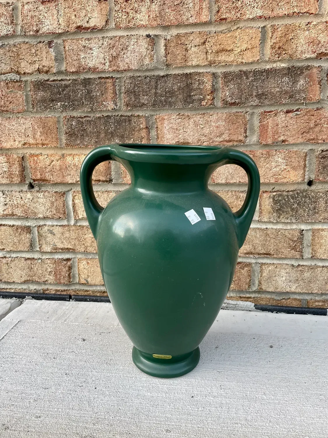 The thrifted dark green two-handled vase before painting, price sticker still on it