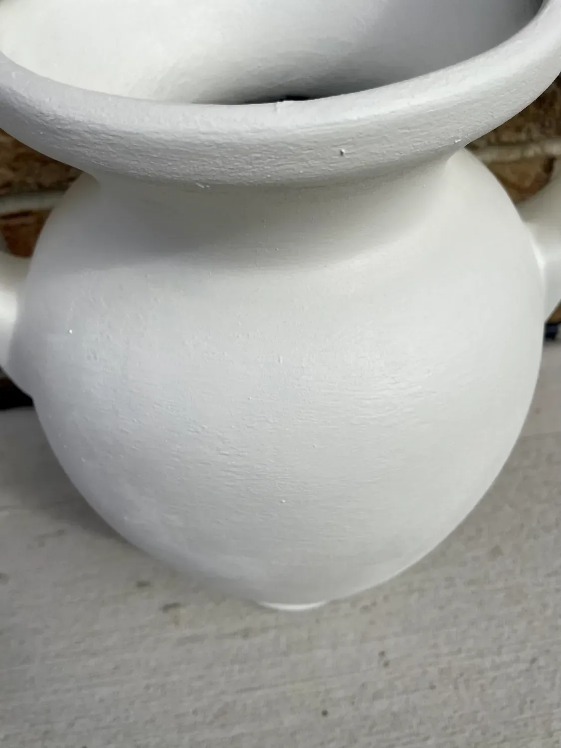 A close view of the vase after its second coat, the surface chalky and matte