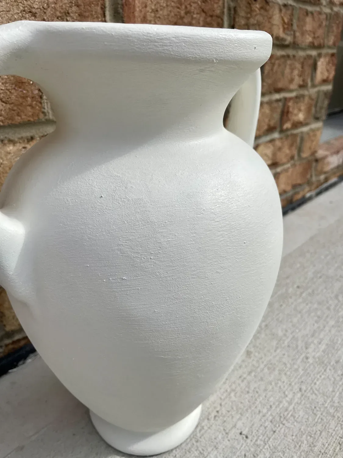 The dried white vase seen close, the baking soda leaving a fine grainy surface