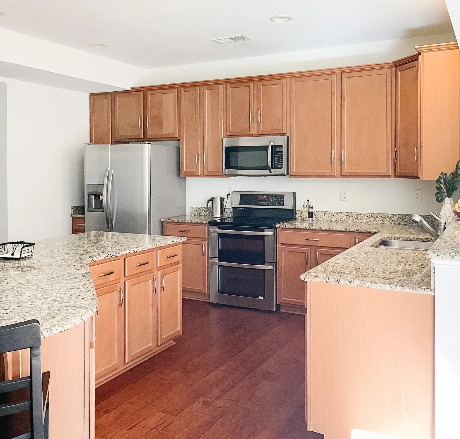 The kitchen's honey-oak cabinets with their original builder-grade handles and granite counters