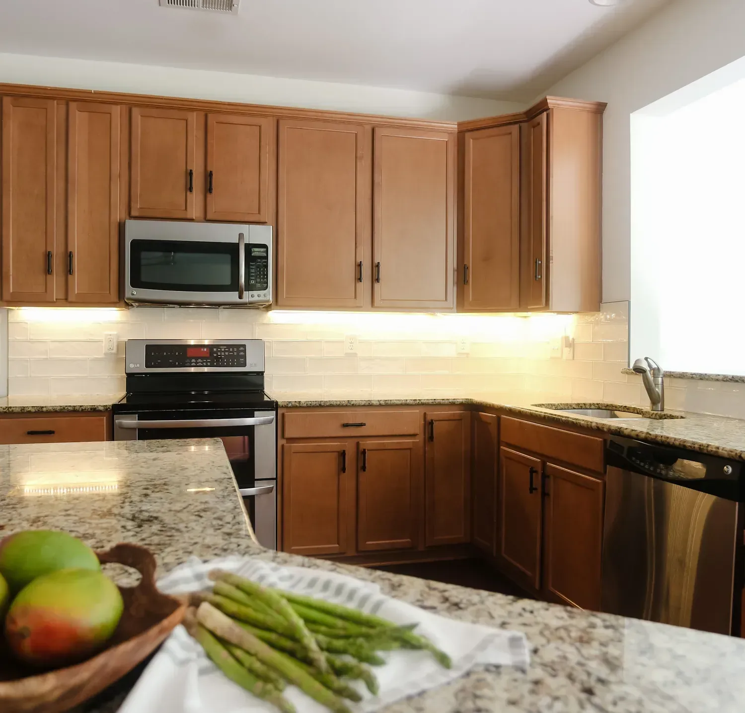 Westhighland White walls above honey-oak cabinets and granite counters in a kitchen