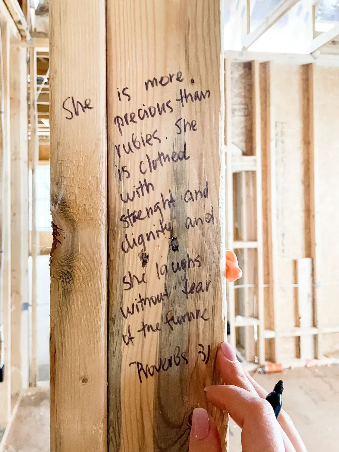 Proverbs 31 written in marker down a wall stud, the pen still in hand