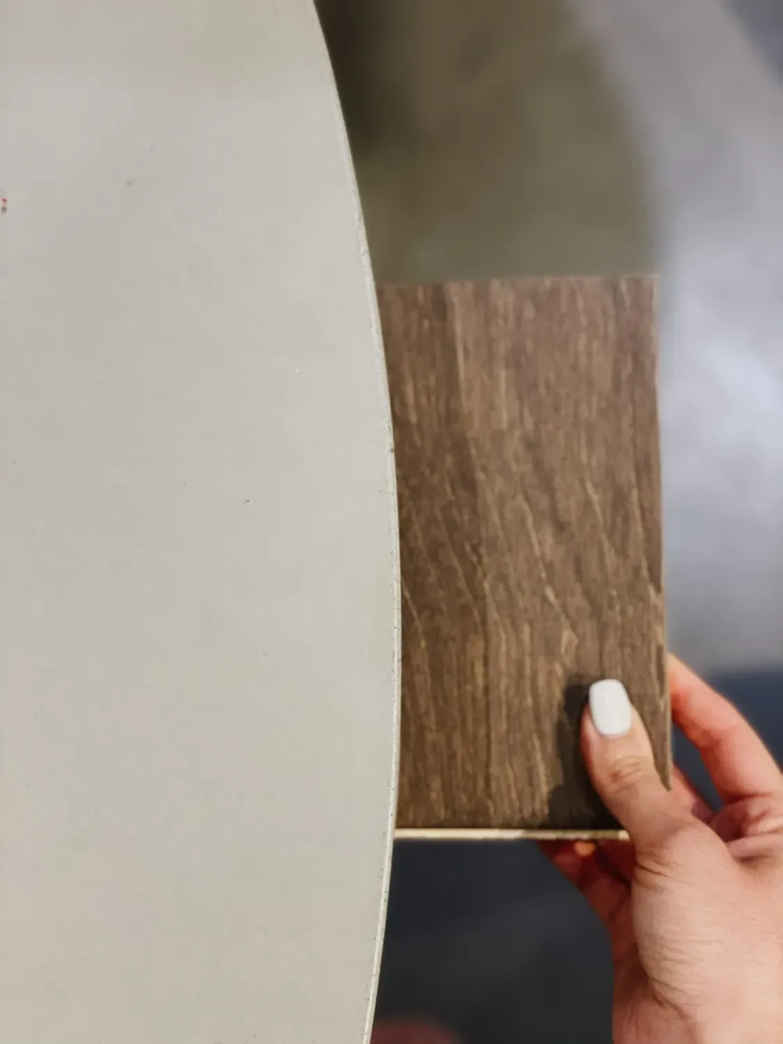 The floor sample held against a pale grey table edge to test the match