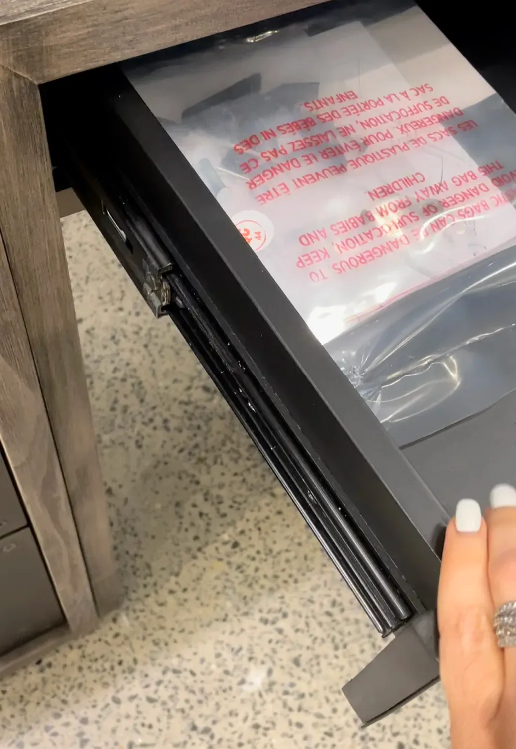 A drawer pulled open on a grey-washed side table to check that it runs smoothly