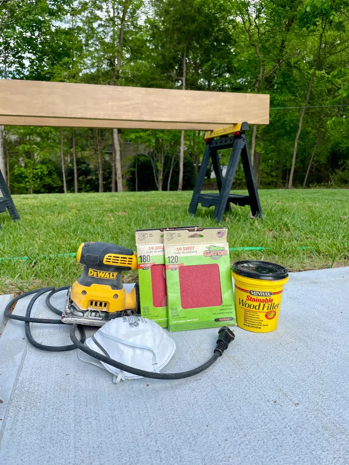 The tools for this step: a palm sander, 120- and 180-grit paper, wood filler and a dust mask