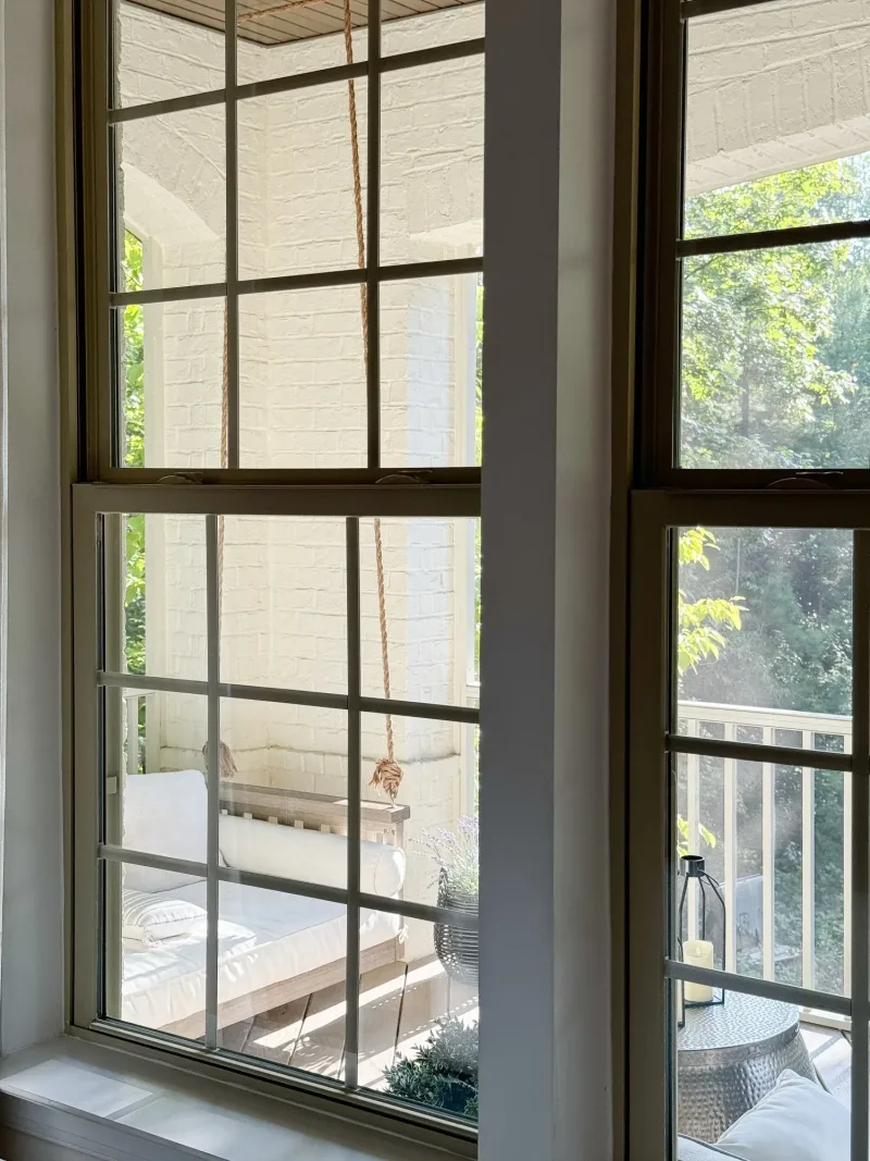 The porch swing seen from indoors through a paned window