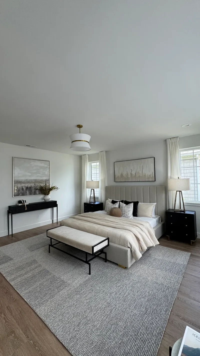 Primary bedroom with a channel-tufted headboard and a gray patchwork rug
