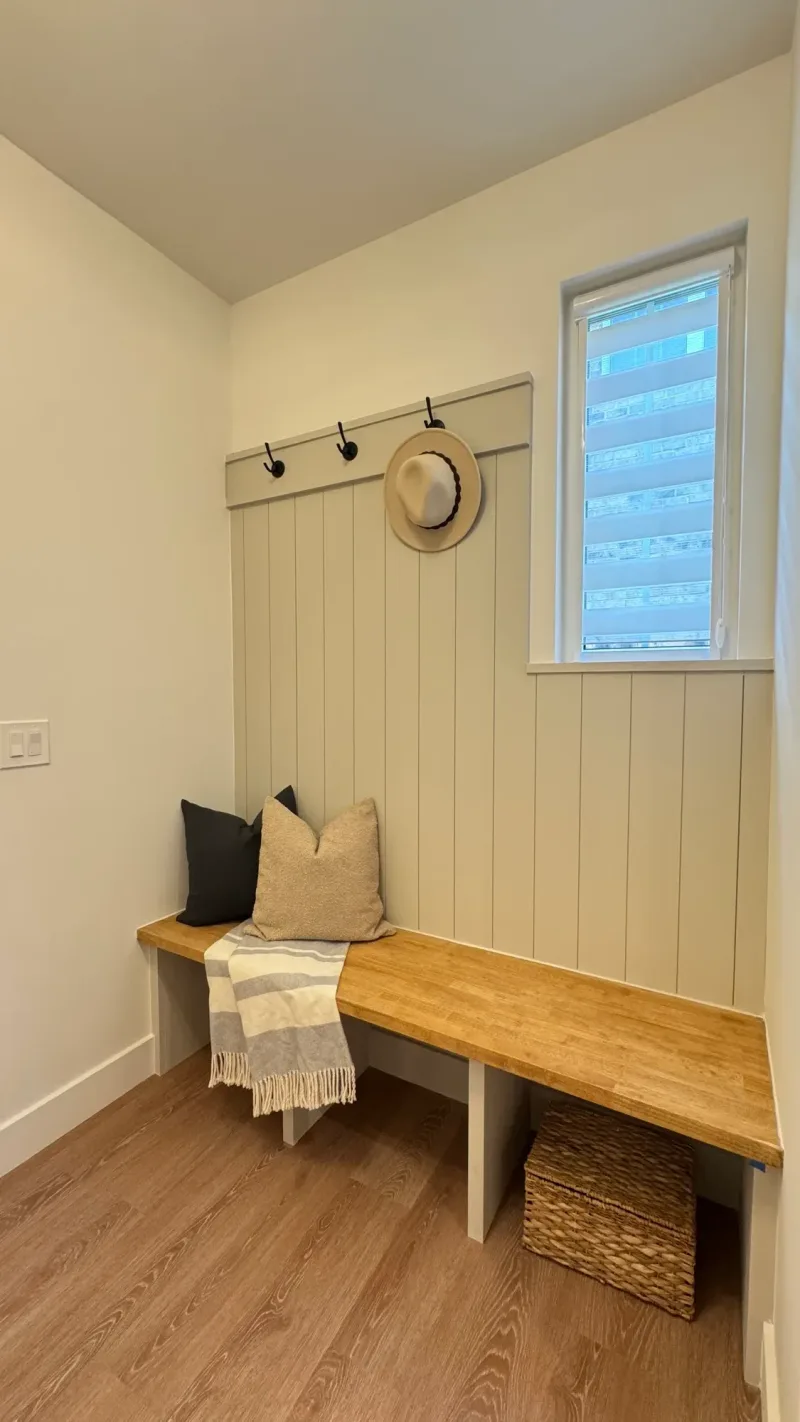 Mudroom bench in board-and-batten with a peg rail and a straw hat