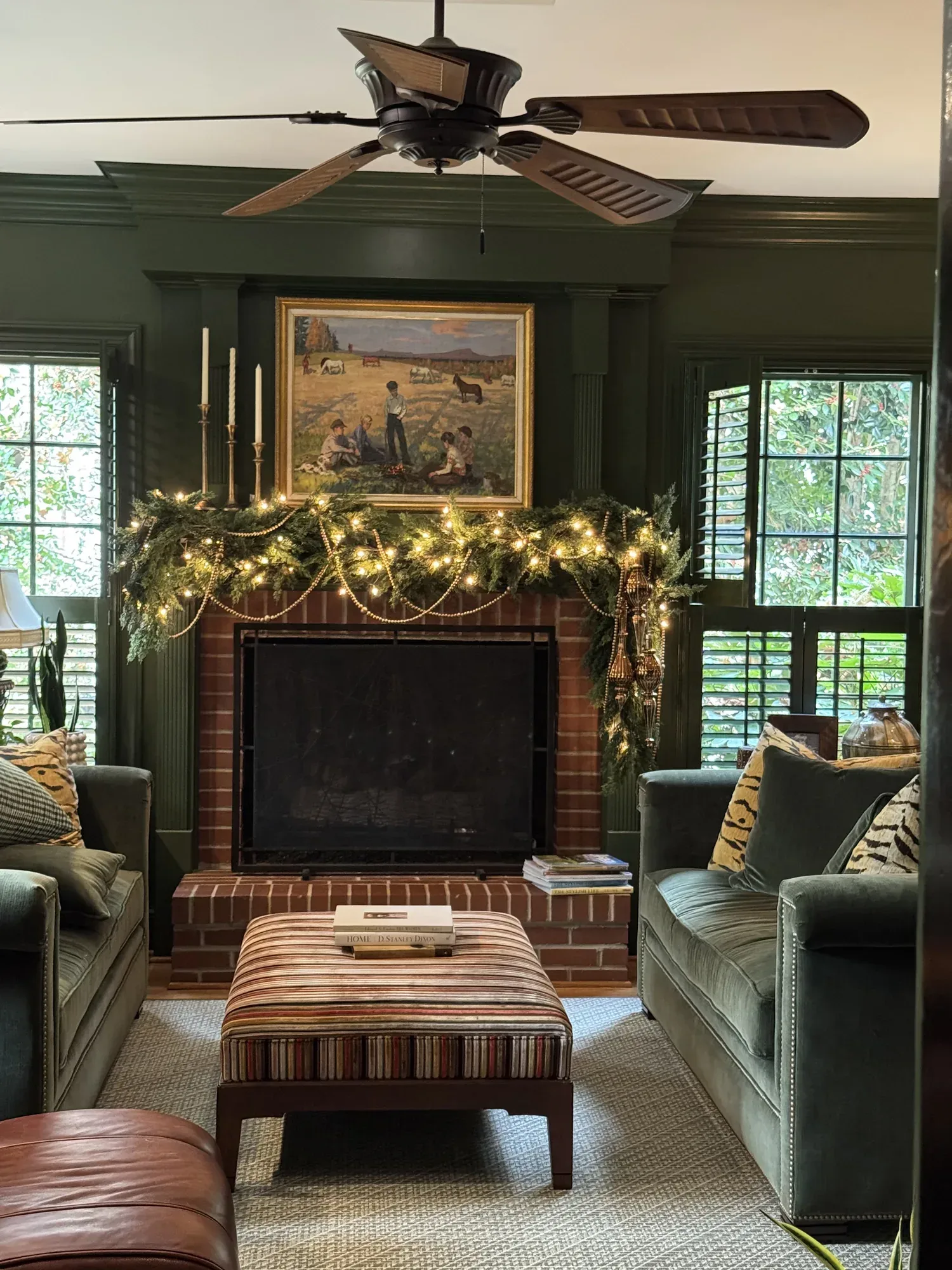 The same green room in the evening, the mantel garland lit with warm lights