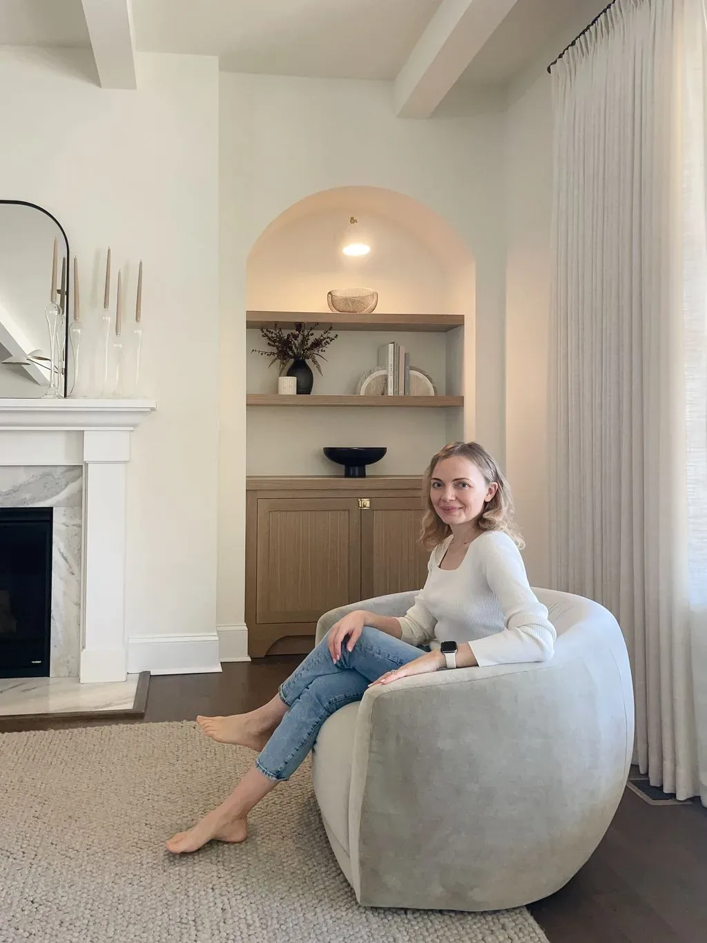 Tatyana seated in a bright, finished living room