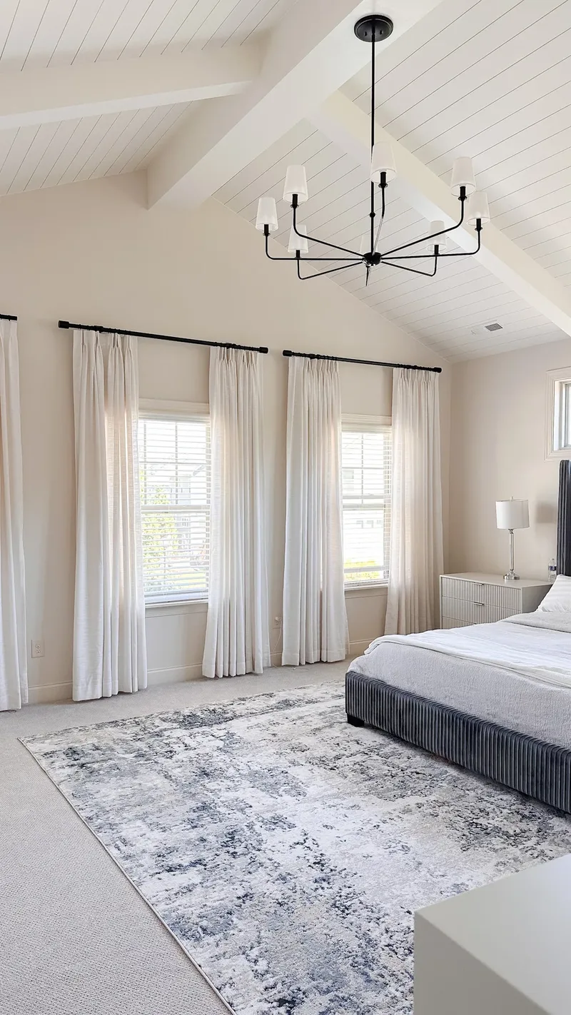 The window wall a step wider, chandelier overhead and the rug filling the carpeted floor