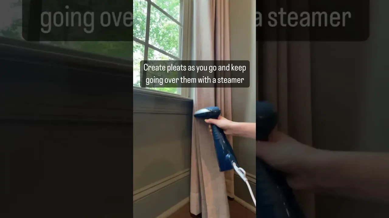 Video still: a handheld steamer run down a curtain panel to set the pleats