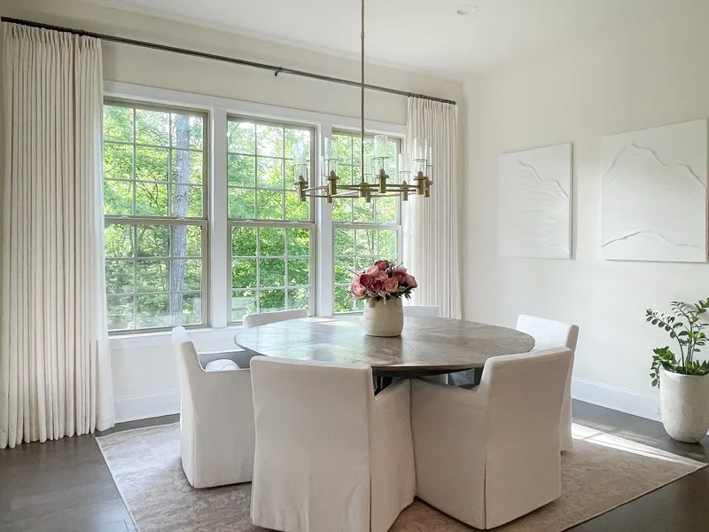 From the corner, both the window wall and the pair of plaster artworks in one frame